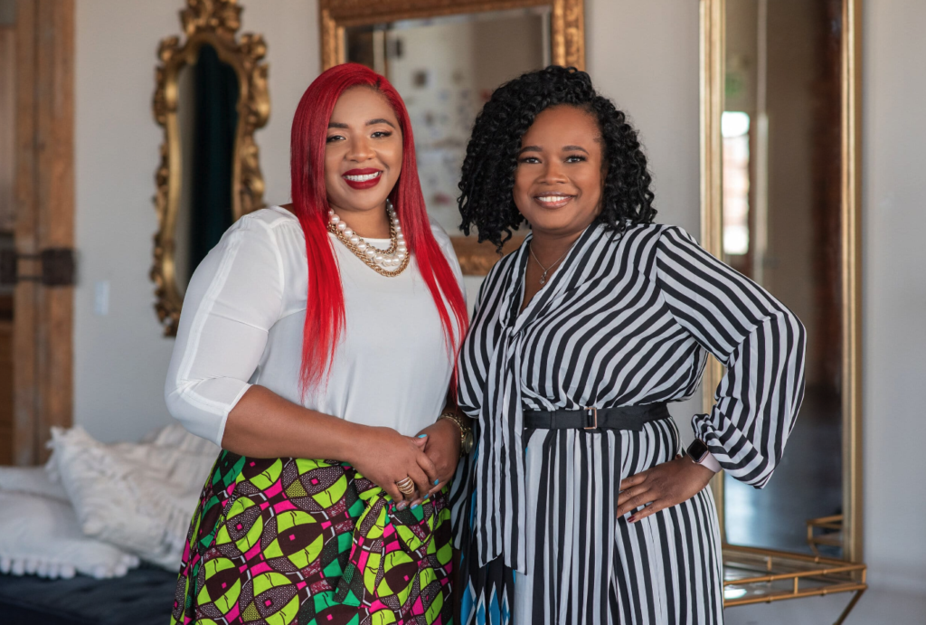 Tenisha and Da'na standing in an office room smiling